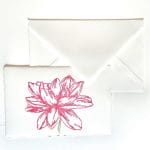 Table markers for receptions in handmade paper and matching ivory envelope. On the place card is engraved, in a handmade way, a Dahlia with pink petals.