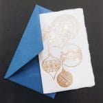 Bigliettini di Natale in carta di Amalfi con decori a rilievo realizzati con dorature eseguite a mano. In copertina una classica illustrazione di alcuni addobbi natalizi